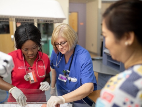 Nurses examine a patient in the NICU